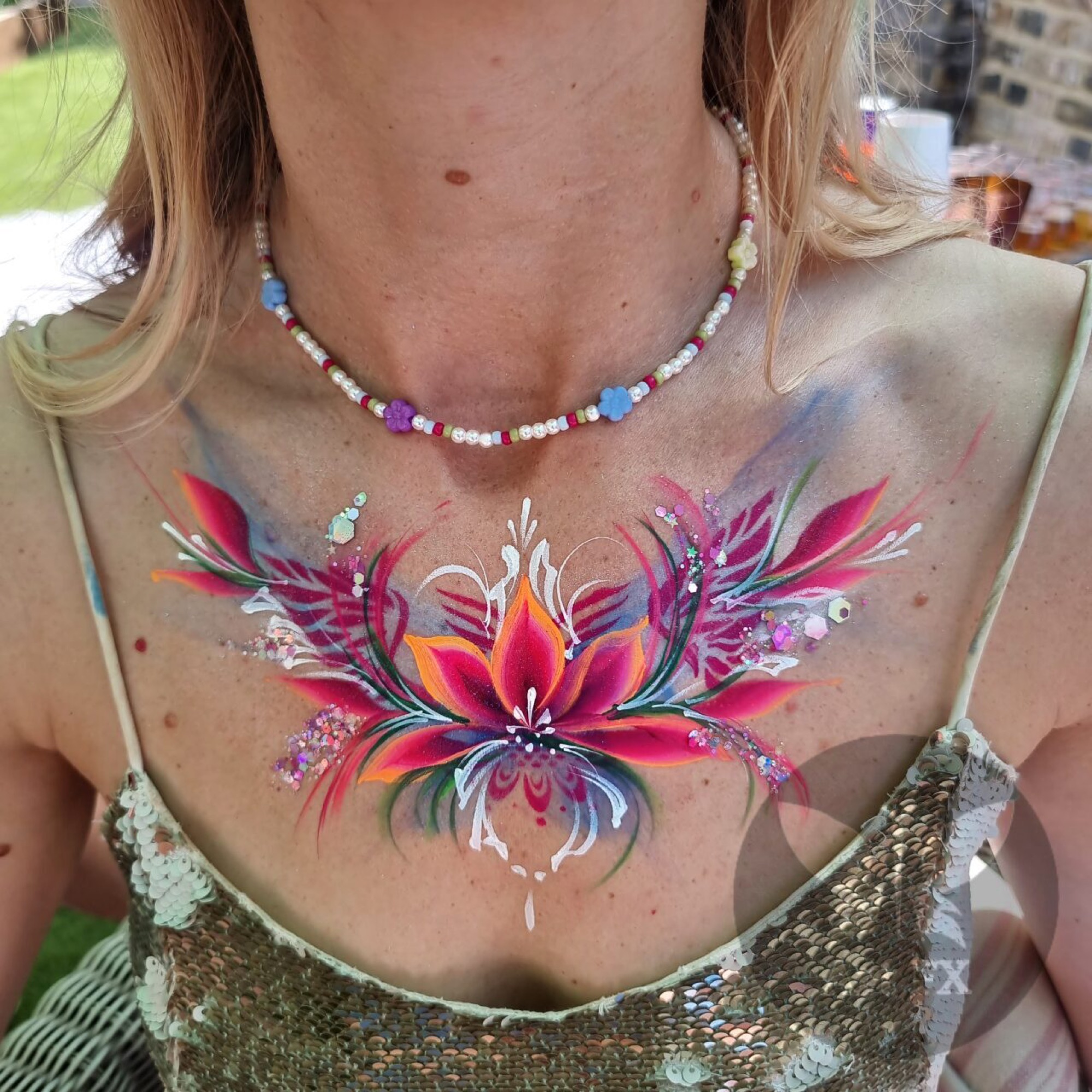 Beautiful pink floral and abstract chest and body painting design on an adult woman