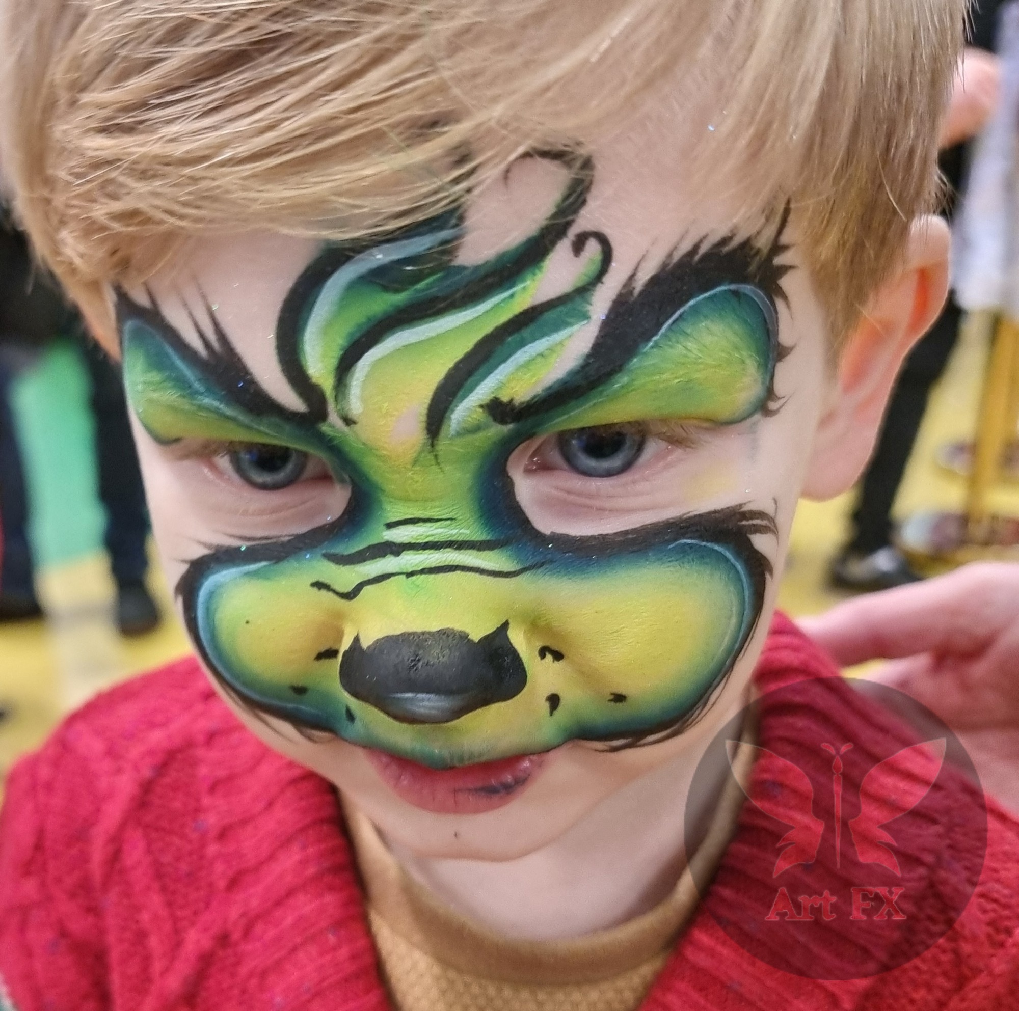 The Grinch face paint on a boy.