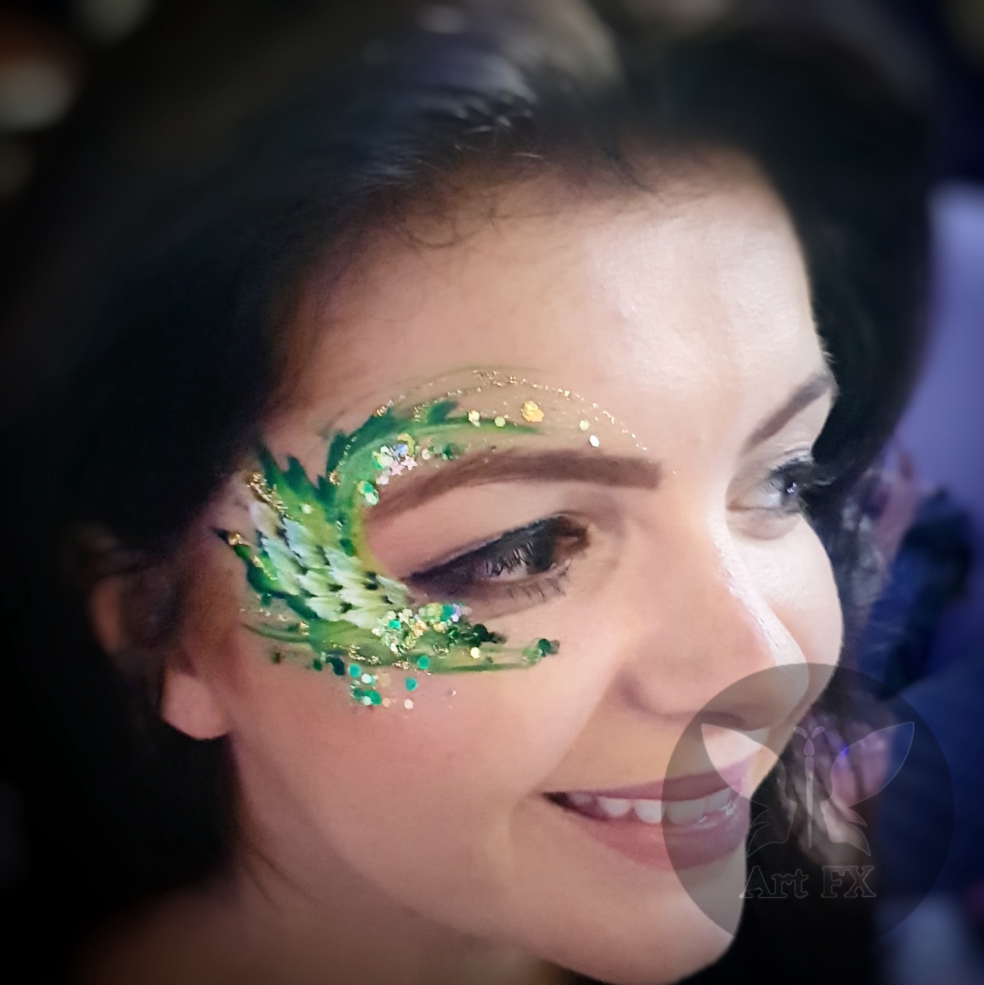 A woman showing a beautiful red and white floral face paint design with matching chunky glitter on her cheek.