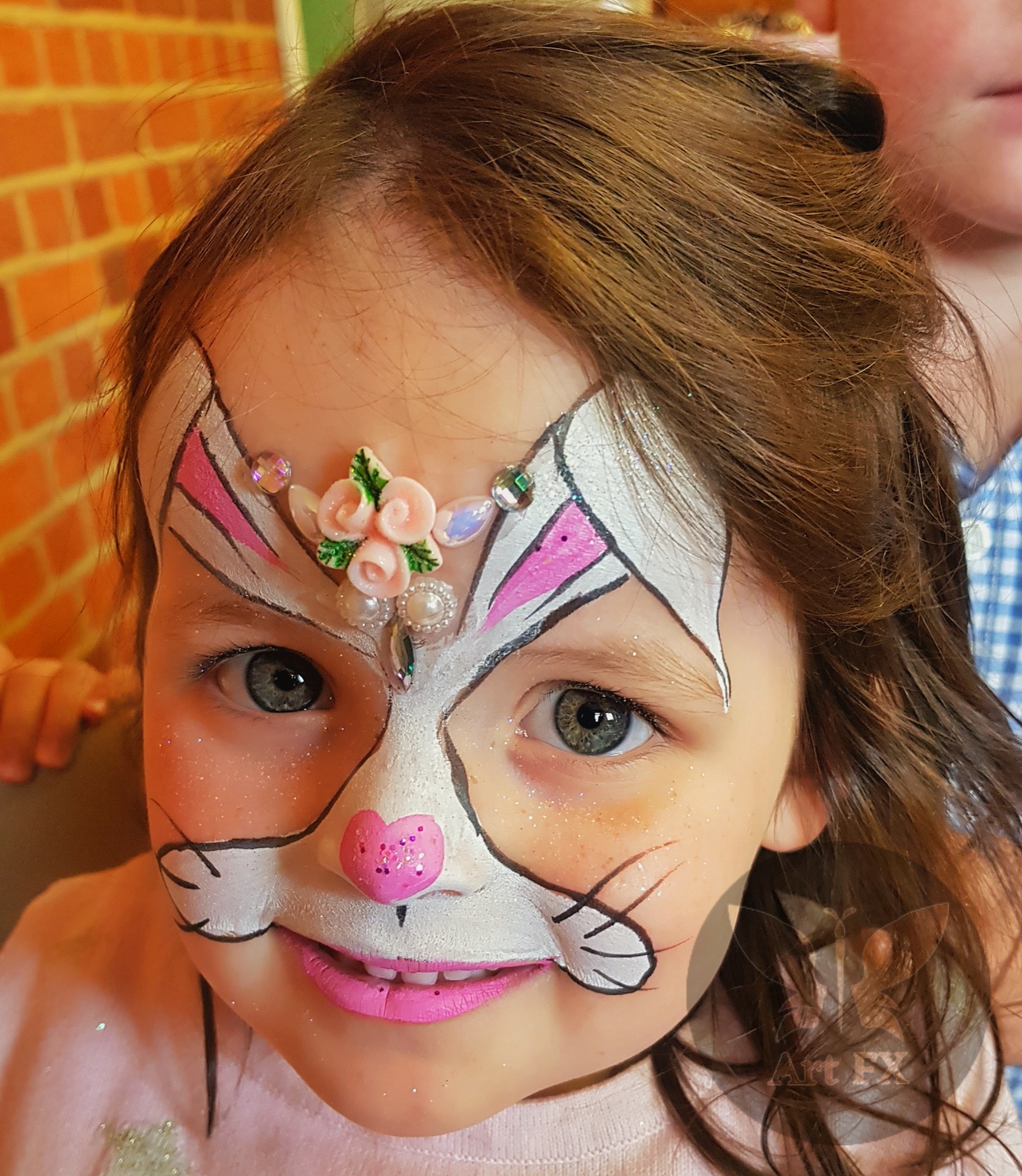 Young boy displaying a vibrant red and blue superhero spider face painting design