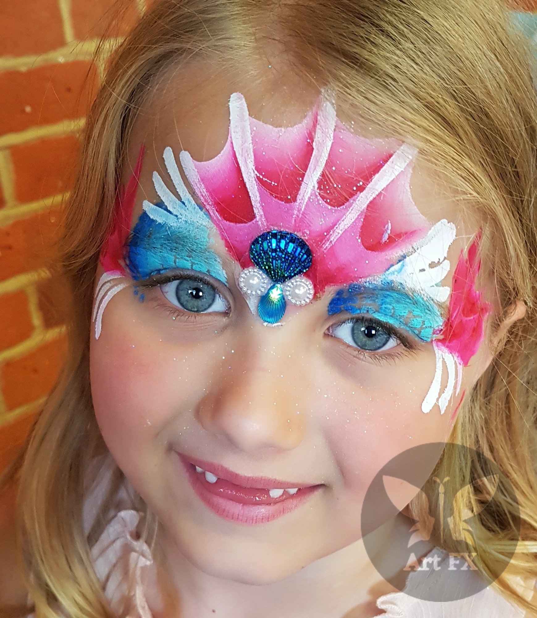 Young boy featuring a detailed red, yellow, and gold superhero face painting design