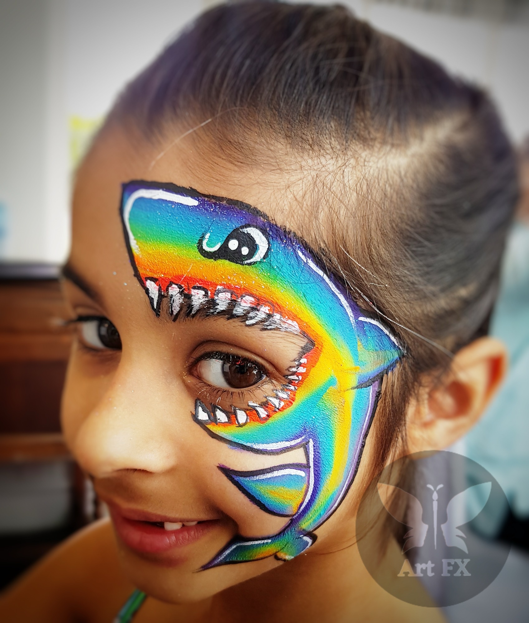 Young boy with a classic bold red and black superhero spider face painting mask