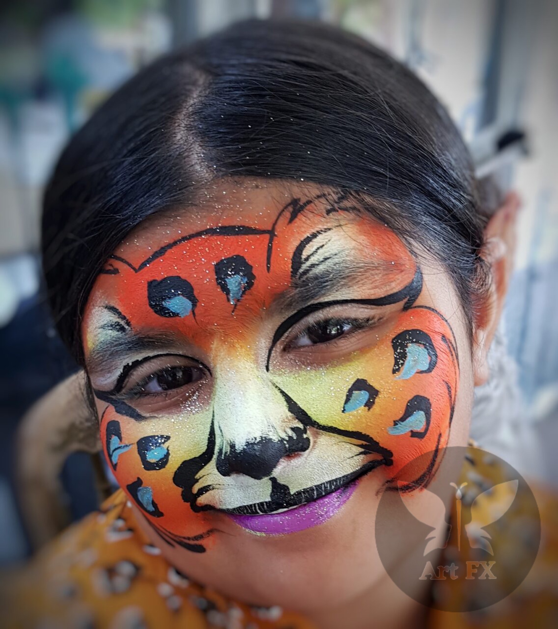 Young boy displaying a green and black superhero face painting mask