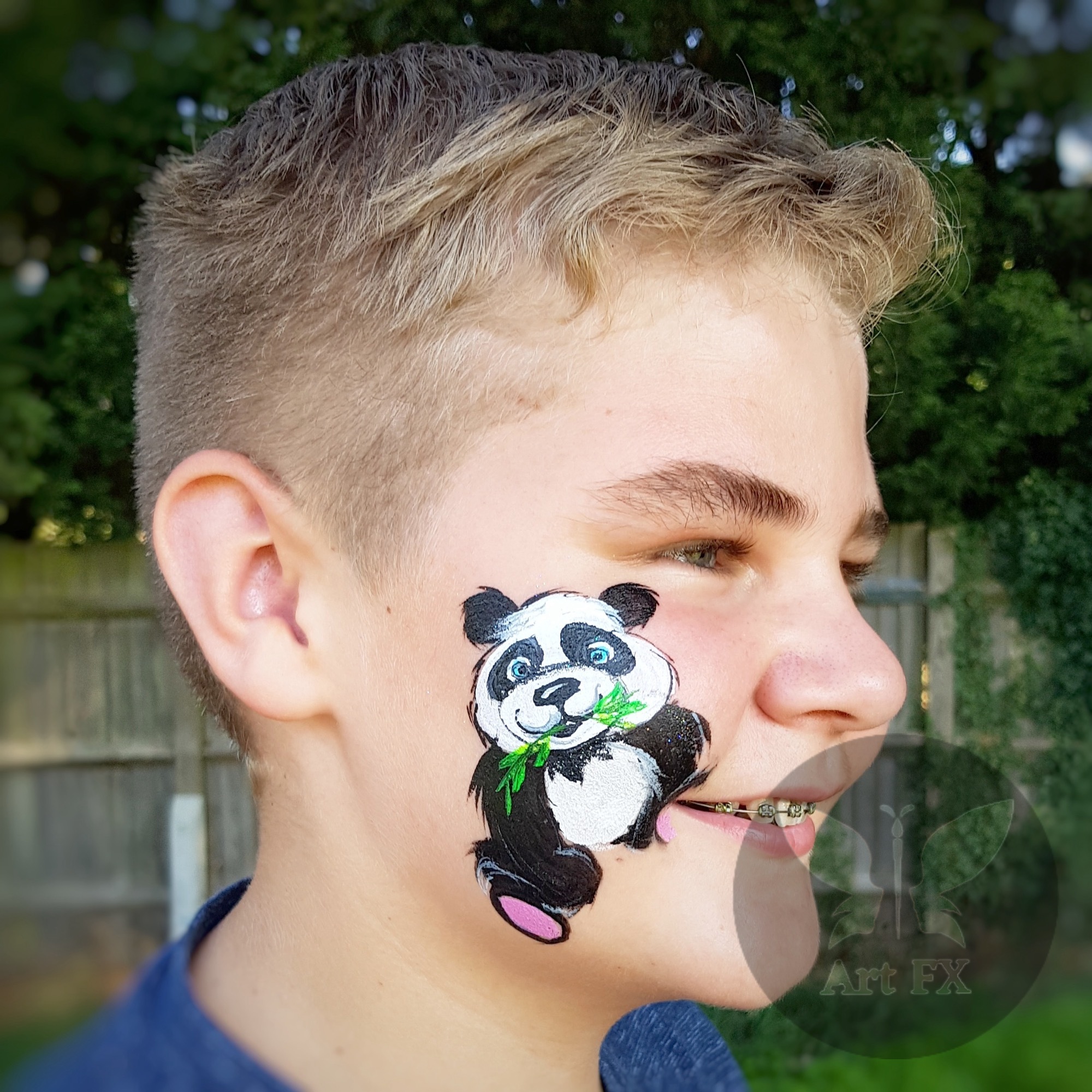 Young boy with a geometric red and black stealth hero mask face painting design