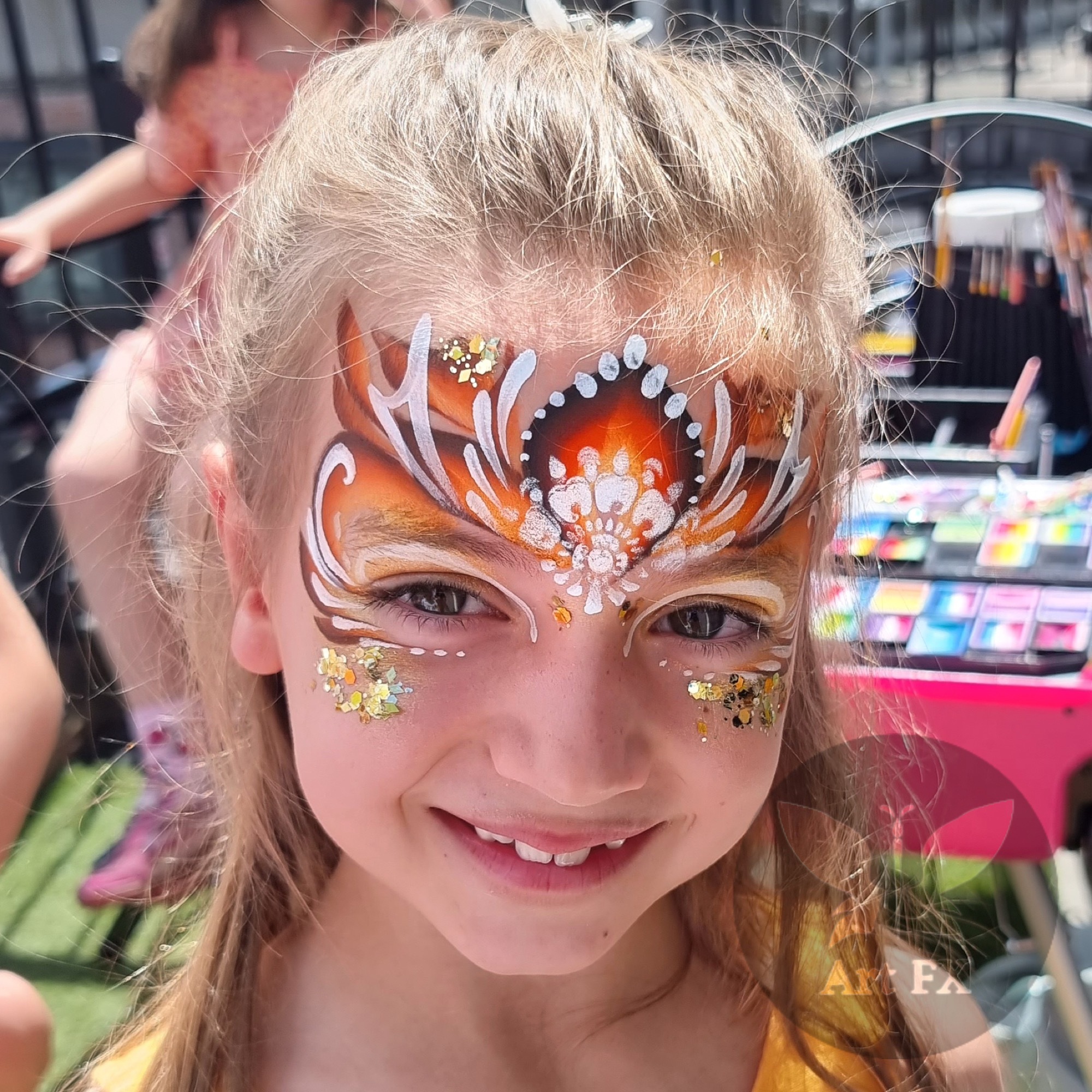 Young boy showcasing a green half-face superhero mask face painting design