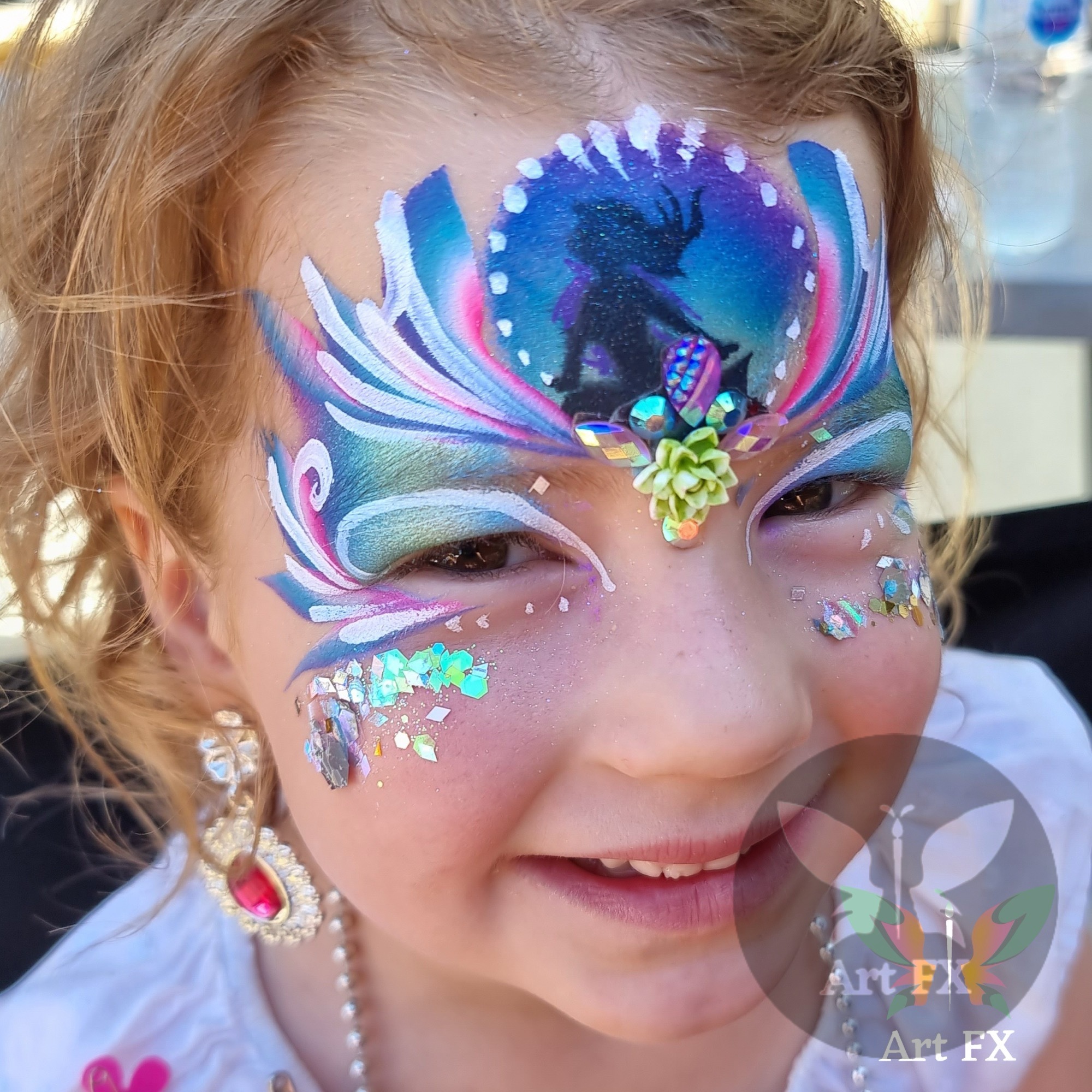 Young boy with a bold red and blue web-themed face painting mask design over his eyes