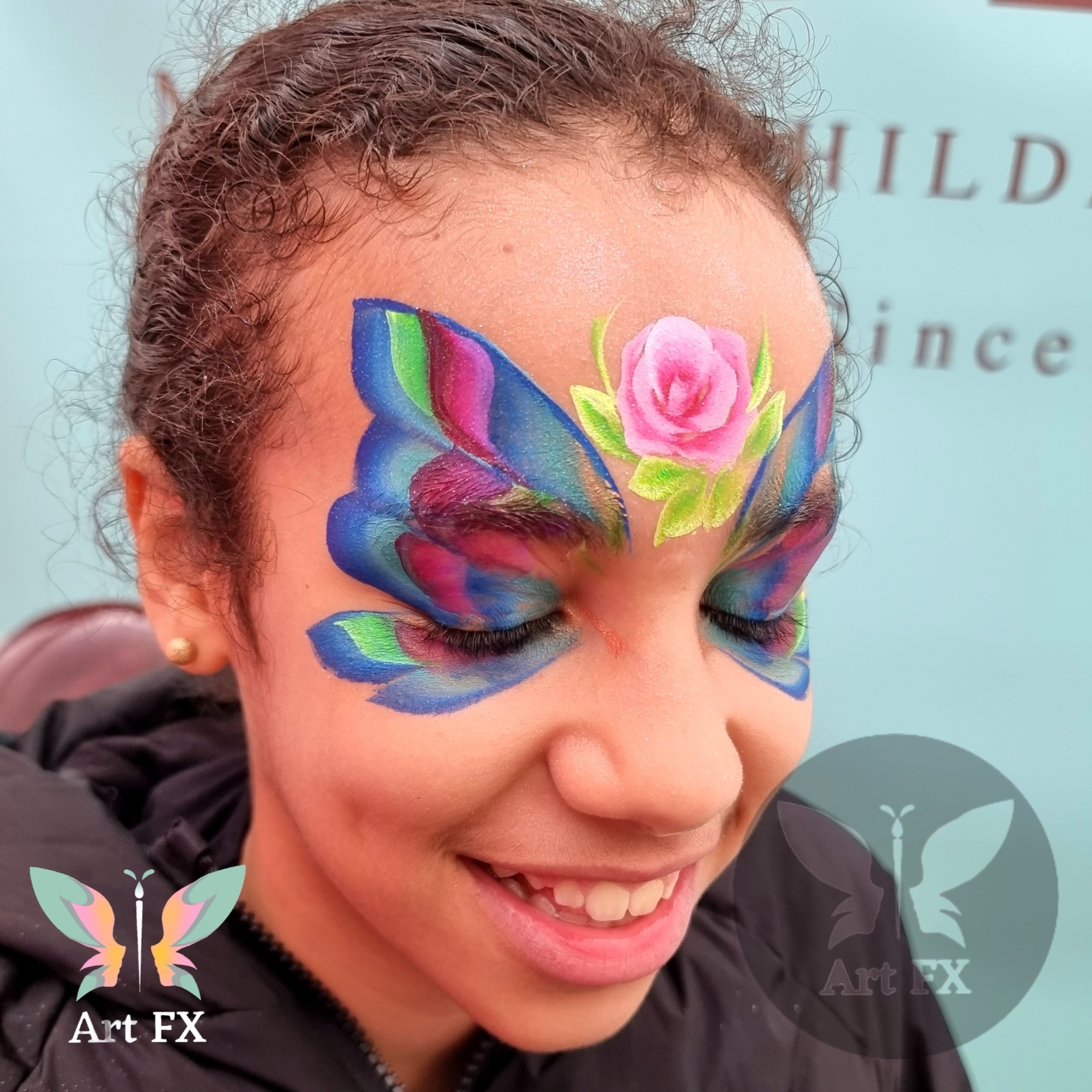 Young child with a green and black comic hero superhero mask face painting design