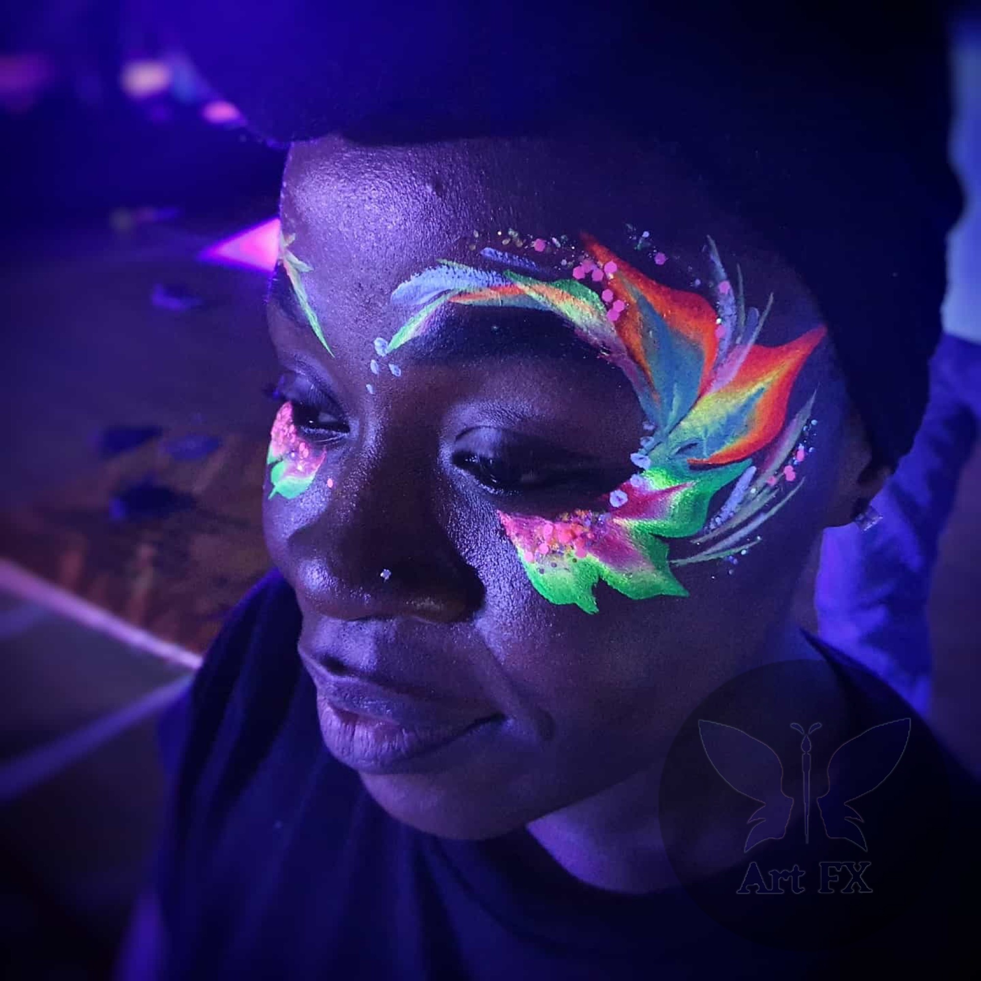 Glowing neon tribal pattern face painting with bright fluorescent colors under UV light